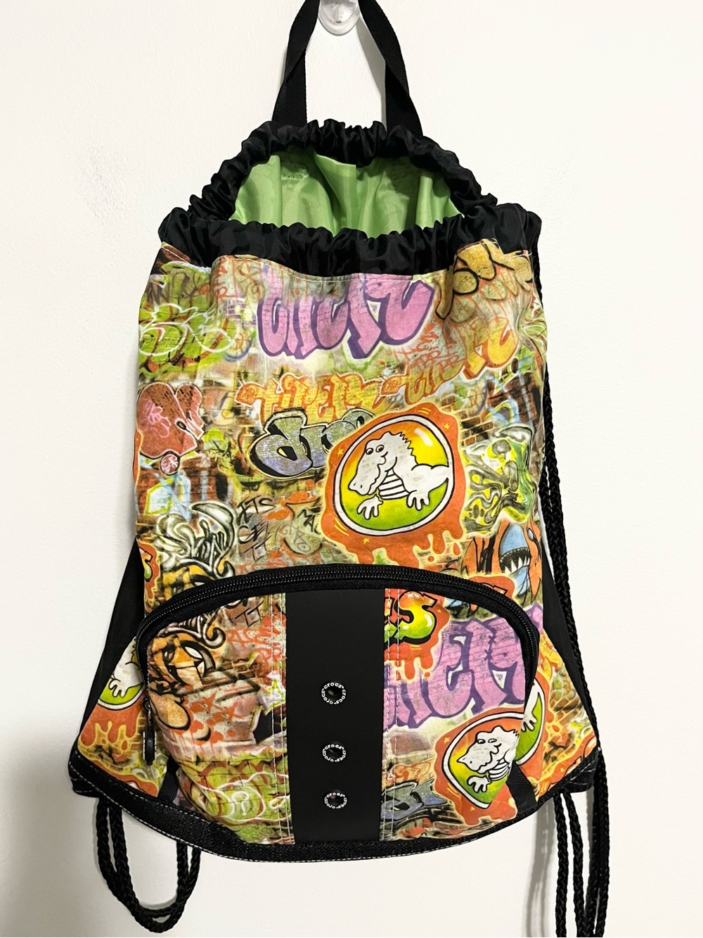 CROCS Graffiti Multicolor Print Cinch Drawstring Backpack. Front Zip Pocket